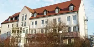 Ein modernes Gebäude hinter herbstlichen Bäumen