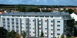 Ein modernes Gebäude mit vielen Fenstern vor blaume HImmel.