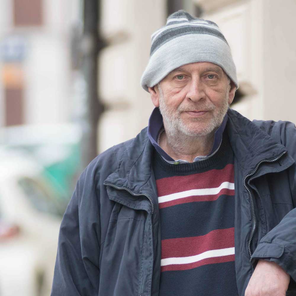 Ein Mann mit einer Mütze sieht in die Kamera