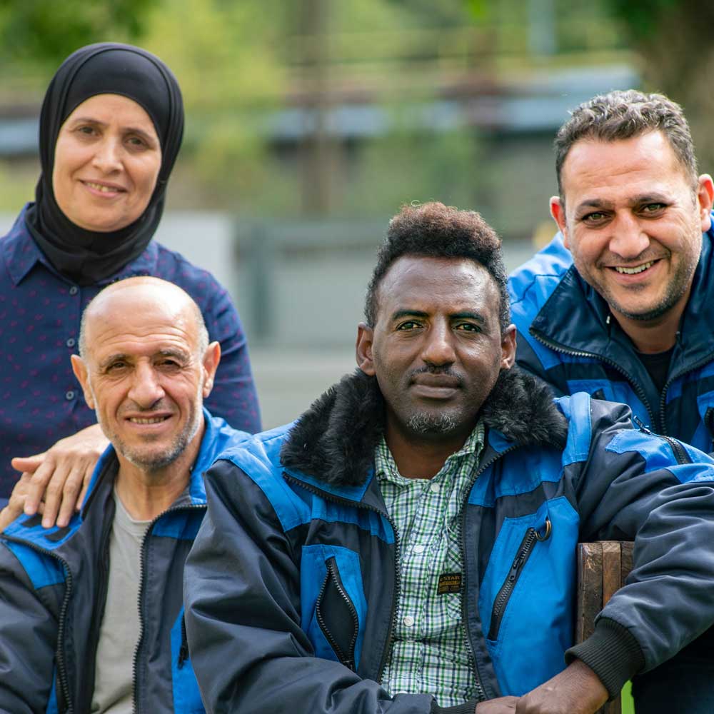 Vier ausländisch aussehende Menschen sehen in die Kamera