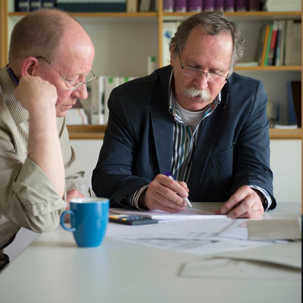 Zwei Männer sitzen an einem Tisch.