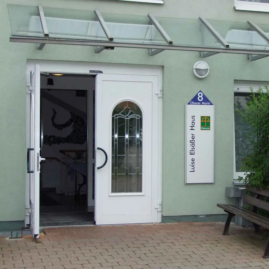 Der Eingangsbereich des Hauses- eine weiße Tür in einer grünen Wand.