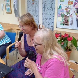 Zwei Frauen in bunter Kleidung singen zusammen